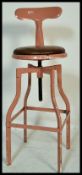 A vintage retro 20th Century machinist stool raised on tubular adjustable swivel legs and base