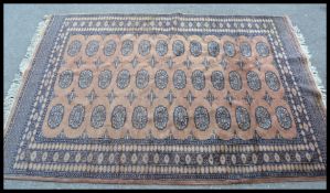 A 20th Century Persian Islamic floor carpet / rug having a red ground with black geometric borders