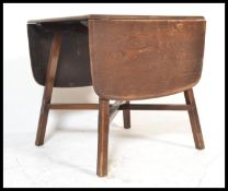 A 20th Century Ercol stained elm and beech wood drop leaf dining table raised on splayed cut and