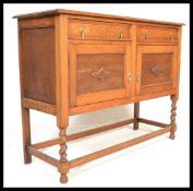 A 1920's oak barley twist sideboard having two short drawers over cupboards beneath, all raised on