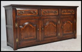 A 20th Century Georgian style Regency Revival mahogany sideboard having a configuration of three