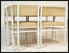 A set of four vintage retro 20th Century faux white leather dining chairs raised on painted white