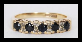 A hallmarked 9ct gold diamond and sapphire ring having 13 stones in a flush eternity setting. Weighs