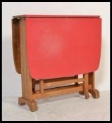 A retro vintage mid 20th Century red formica drop leaf dining table raised on square beech wood