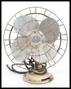 A vintage retro 20th Century industrial desk top table fan by Limit raised on a circular base the