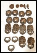 A large collection of approximately 14 architectural salvage cast iron Lion mask door knockers, some