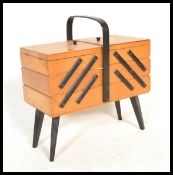 A vintage 20th Century beech wood concertina metamorphic action sewing / work box, ebonised carry