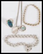 A collection of silver jewellery to include a a heart lock bracelet on a curb link chain, a rope