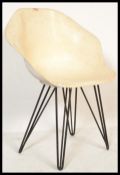 A vintage retro circa 1960's fibreglass tub chair in the manner of Arkana raised on ebonised hair