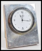 A P. J. Carr silver hallmarked easel back desk clock having a round white enamelled face set