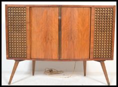 A 1950S DECCA STEREOGRAM in walnut case, with semi-bow front tambour doors to the centre flanked