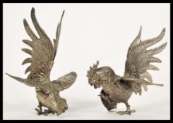 A pair of early 20th Century silver plated fighting cocks fireside figurines depicting two cockerels