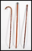 A group of three 19th / 20th Century walking stick canes to include a palmwood example, a hallmarked