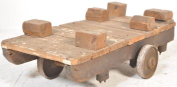 An antique vintage industrial wooden framed cart dolly trolley of simple wooden construction with