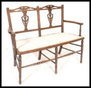 An early 20th Century Edwardian mahogany framed lovers / conversation seat, with carved fret pierced