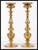 A tall pair of early 20th Century solid heavy brass ecclesiastical church altar candlesticks