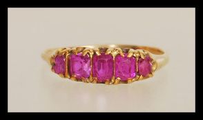 An early 20th Century 18ct gold ring prong set with five rectangular cut pink stones. Unmarked but