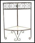 A vintage 20th century glass and forge metal corner table / side table, having scroll decoration and