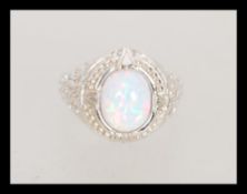 A stamped 925 silver dress ring set with an opal cabochon with pierced decoration celtic knot design