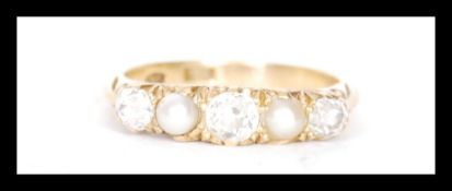 A stamped 18ct gold ring set with three old cut diamonds and and two pearls. Weight 3.3g.