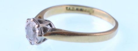 A modern 18ct gold and diamond solitaire ring. The round brilliant illusion set in round and yellow.