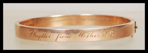 A hallmarked 9ct gold bangle having a hinged openi