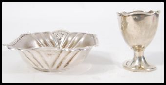 A silver hallmarked egg cup raised on a circular b