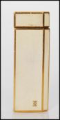 A vintage 20th Century Cartier gold plated cigarette lighter having cream enamelled panels and one