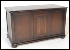 A 20th century oak blanket box in the manner of Ercol. The chamfered edge top over fielded panel