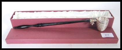 A bee keeping interest silver hallmarked 925 candle snuffer with bee hive end raised on ebonised