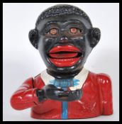 A vintage 20th Century cast iron money box ' Little Joe Bank ' having a mechanical arm, being hand