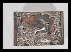An early 20th Century silver hallmarked matchbox holder having repousse decoration of a stag with