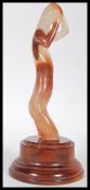 A 20th Century carved agate figure sculpture in the form of a nude female with raised arms on a