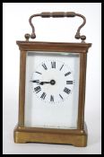An early 20th Century French gilt brass cased carriage clock. The white enamel face with Roman