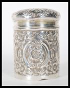 An early 20th Century silver hallmarked dressing table powder pot having repousse floral