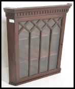 A 19th century mahogany hanging corner cabinet of small proportions having a flared pediment over