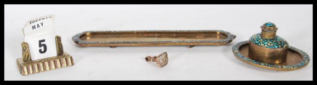A 20th Century brass writing desk set having turquoise stone set borders to include a lidded