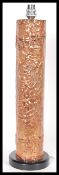 A mid 20th century copper table / desk lamp of cylindrical form, the body of the lamp in relief