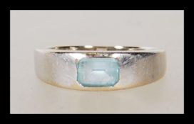 An 18ct white gold aquamarine single stone ring. The aquamarine in a rub over setting. Unmarked,