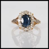 A hallmarked 18ct gold ladies dress ring set with an oval cut sapphire with a diamond halo.
