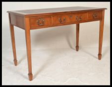 A 20th Century Georgian revival writing table / desk, inset tooled leather skiver over three drawers