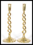 A pair of 20th Century brass candlesticks having a dual spiral twist stems raised on circular