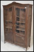 A 20th century French armoire bookcase cabinet. Raised on shaped legs with twin fielded glass