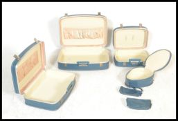 A set of mid 20th Century graduating vintage vanity travel trunks having blue exteriors and fitted