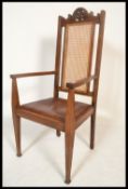 A Victorian Arts & Crafts oak carver cane back armchair. Raised on square tapering legs with