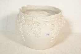 A 20th Century Antique style ceramic jardiniere / planter, glazed white body, having floral and leaf