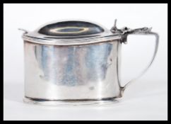 An early 20th Century Edwardian silver hallmarked mustard pot of ovular form having a shaped