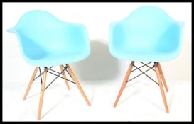 A pair of Eames style DSW chairs. The armchairs in blue. Raised on tapered legs with wirework