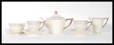 A vintage Art Deco 1920's tea for two service having a cream ground with silver patterning to the