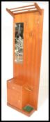 A mid 20th century teak hall stand, having a configuration of drawers and cabinet to left,